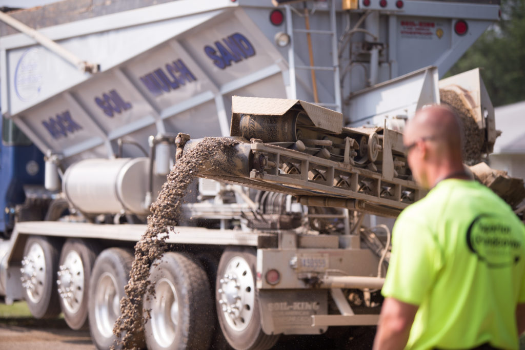 Superior Groundcover team member in front of one of our stone slinger trucks