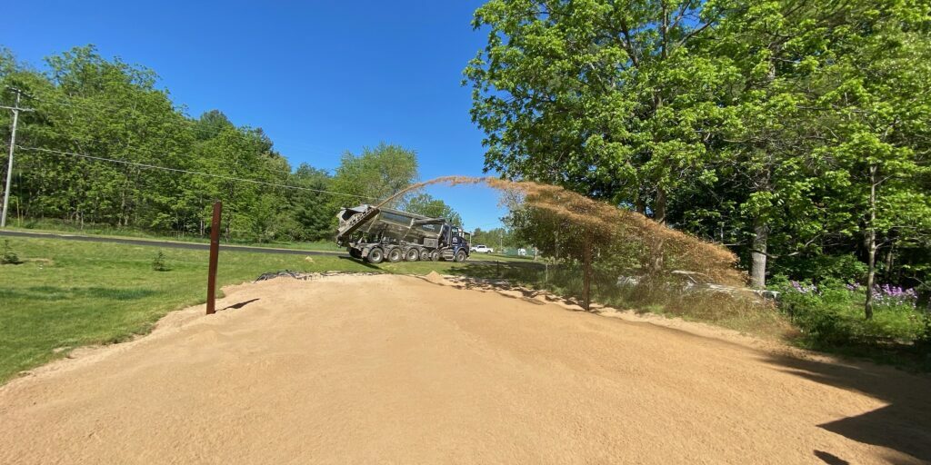 Truck blowing sand in for Volleyball court